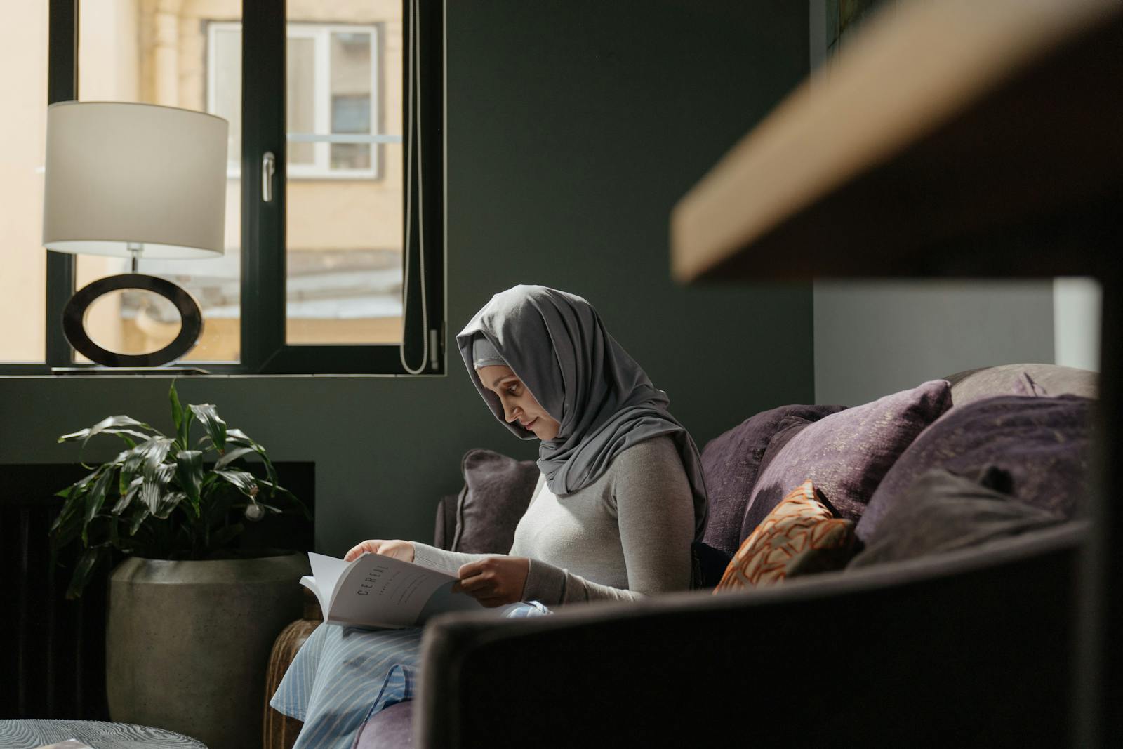 Woman in Gray Hijab Reading Book